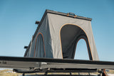 Roof top tent attached to a vehicle with a clear blue sky background