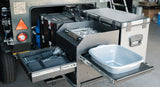 Fully kitted kitchen above a trailer with washing up station, gas cooker, fridge, utensils and food storage containers.\