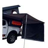 Off-road camping vehicle fitted with a hard shell rooftop tent and an Alu-Cab 270 awning, with the universal side panel in place