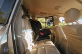 Interior of a vehicle with beige leather seats and a child safety seat.