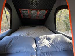 Camping tent interior with a mattress, sheet, two pillows and window view